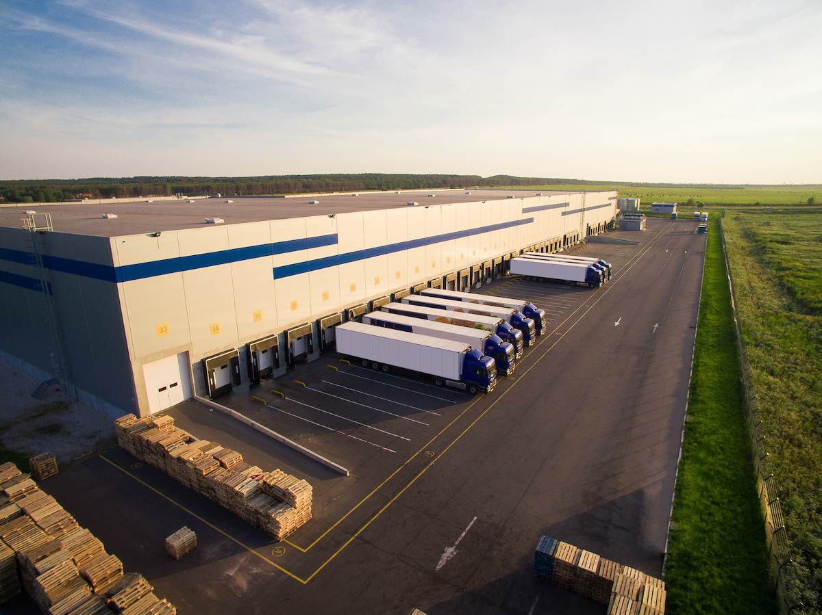 an overhead view of a large warehouse with a row of cargo bays and truck loading docks